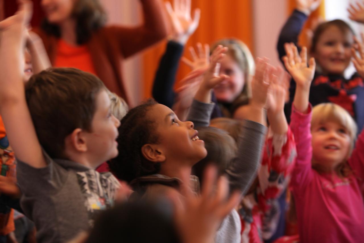 Des enfants levant les bras et souriant