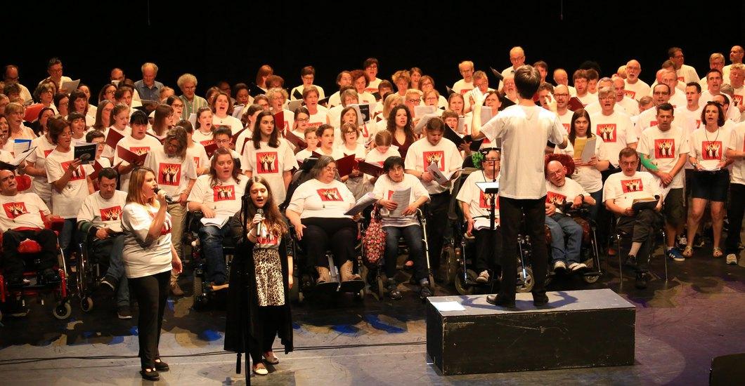 Un groupe de personnes chantant ensemble sur scène