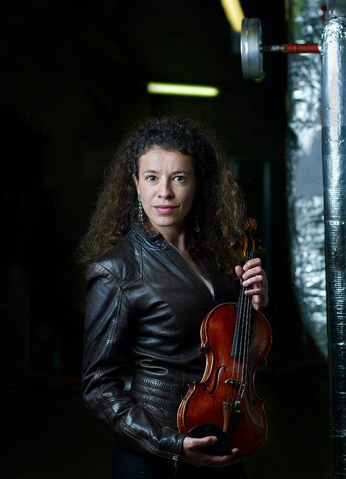 Une femme debout avec un violon à la main