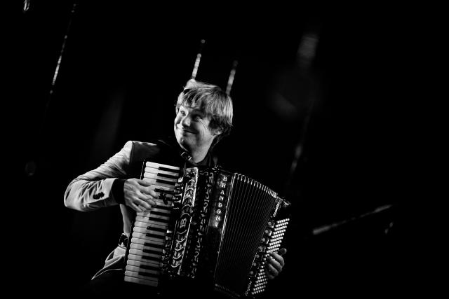 Un homme qui joue de l'accordéon et qui sourit