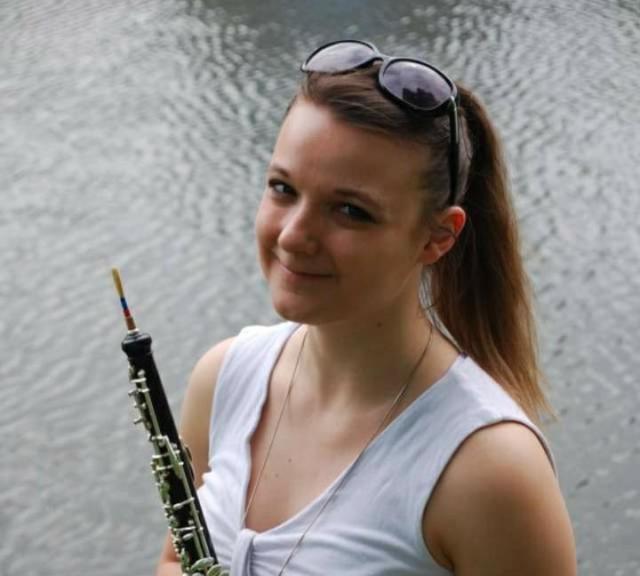 A standing woman with an oboe in her hand