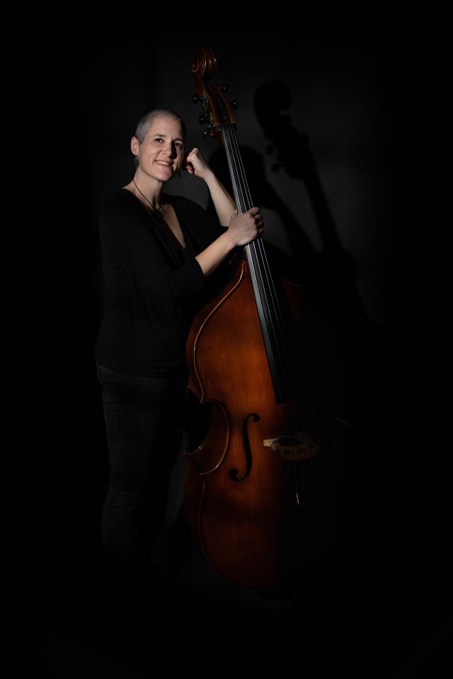 A woman standing by her double bass