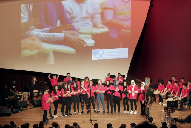 Des jeunes portant un t-shirt chantant ensemble sur scène