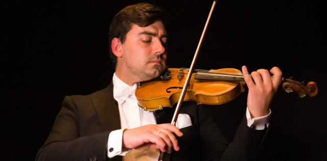 Un homme en costume qui joue du violon