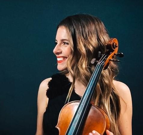 Une femme souriante avec un violon à la main