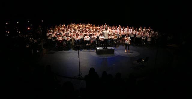 Un groupe de personnes chantant ensemble sur scène