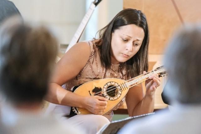 A woman playing the mandolin