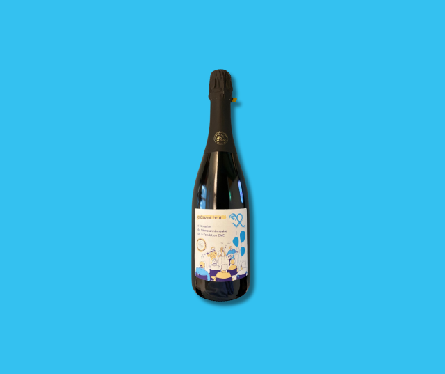 Bouteille de crémant EME sur un fond bleu