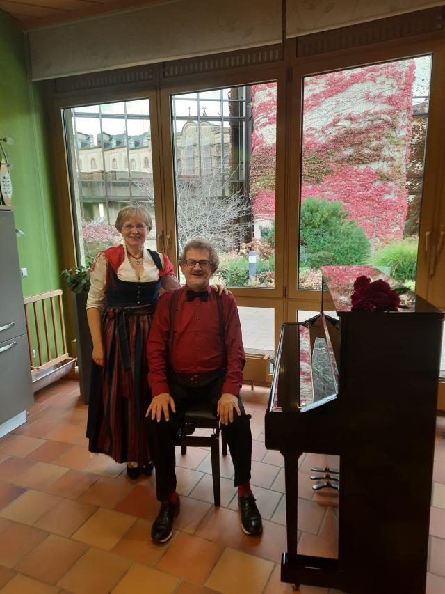 a man and a woman sitting by a piano