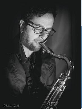 A man in black and white playing the saxophone